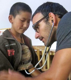 student clinician volunteer listening to a boy's heart