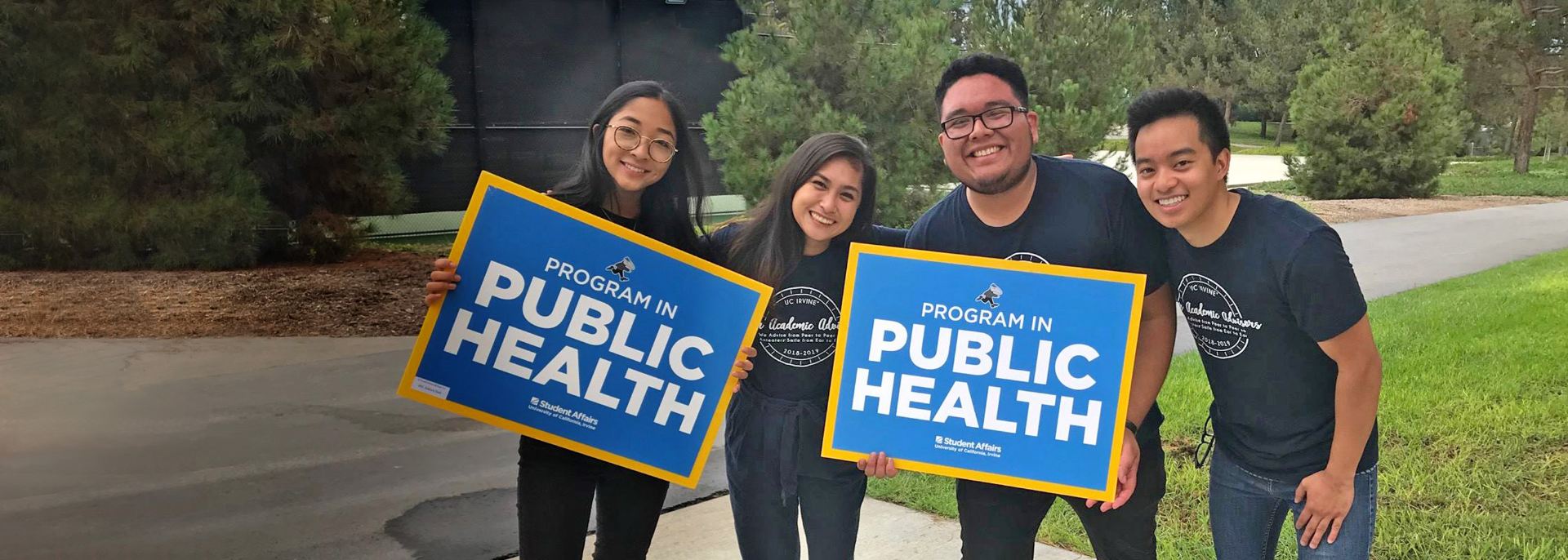 students hold public health signs
